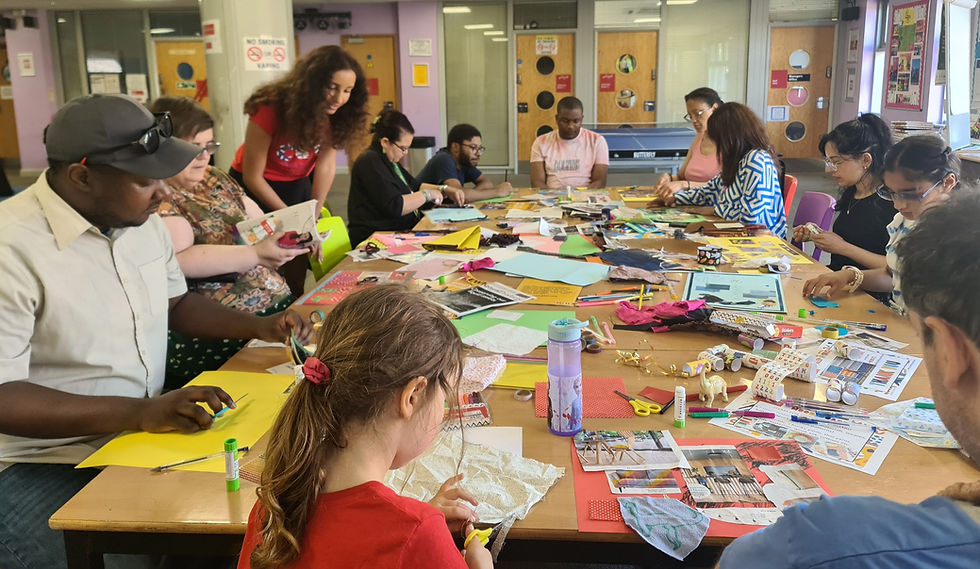 12 people are gathered around a large table creating mood boards for a Feeling Heard and Valued Mood Board Workshop with Adult & Health (DASS) 2023