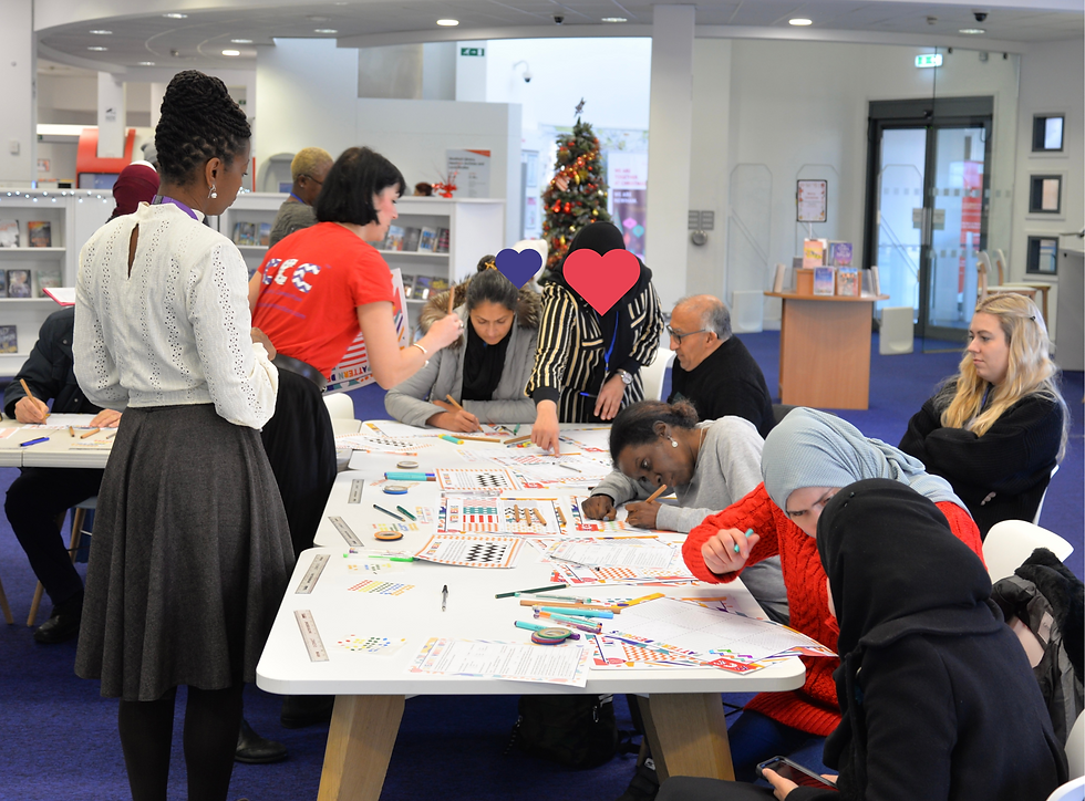 9 people are gathered round a table creating patterns for a Newham Council, Deafroots and SKILLS Community Mural Project, Newham 2023.