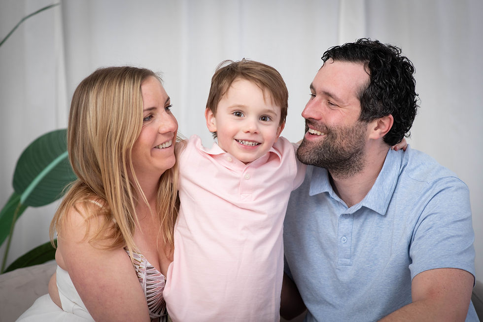 Smiling family with mother, father, and child, reflecting the importance of whole-family wellness and care for parents at Take Care Mama.