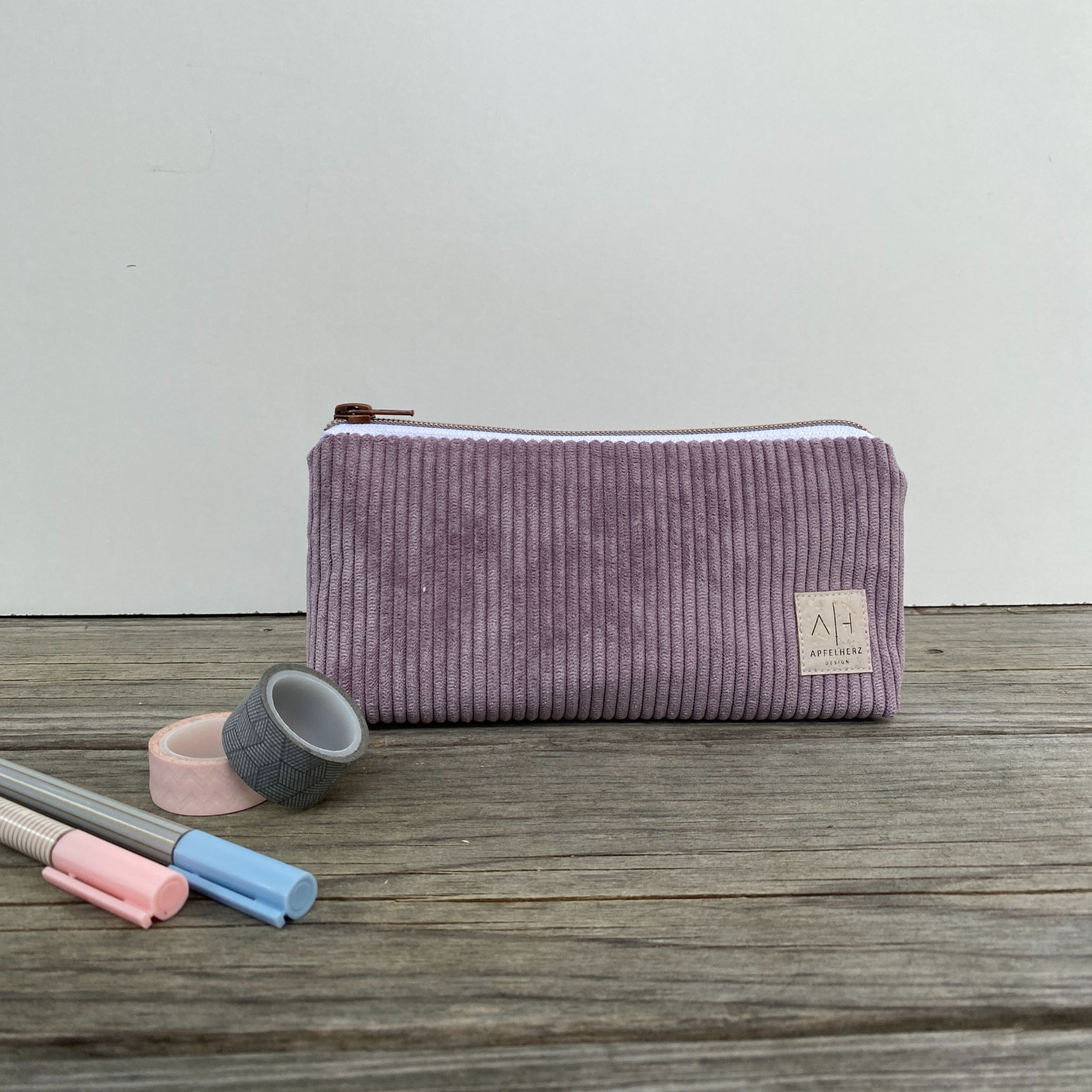 Federmäppchen aus lilafarbenem Cordstoff mit Reißverschluss.