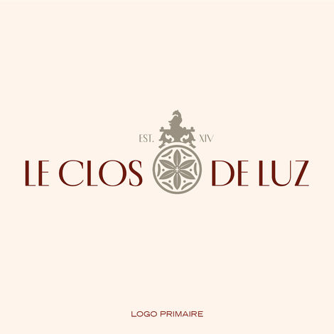 Logo principal du Clos de Luz avec typographie à empattements et blason orné de détails floraux et de l'inscription « EST. XIV »