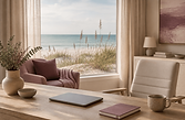 Serene coastal telehealth office with a closed laptop, mauve notebook, ceramic mug, and Gulf water and sea oats visible through the window.
