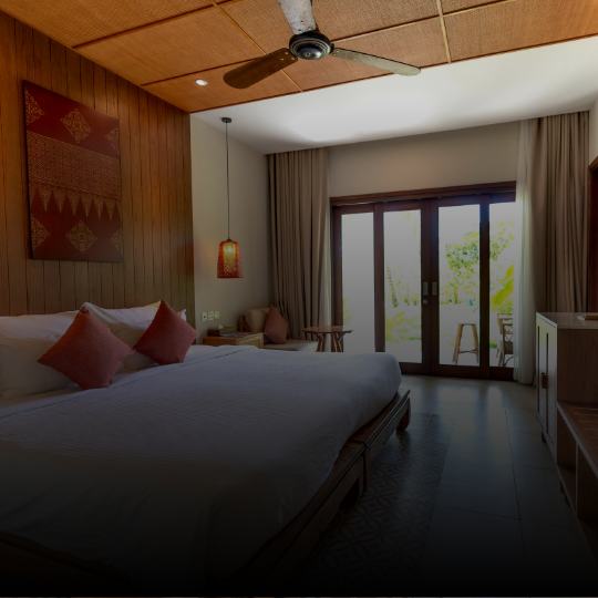 Quiet hotel guest room with a made bed, ceiling fan, and sliding doors