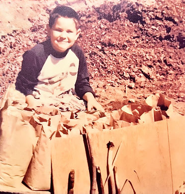 A faded photo of RB as a child surrounded by paper bags outside.