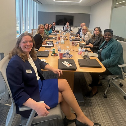 Group of nonprofit professionals around a conference table smiling after a session lead by Elise Woodworth.