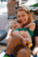 Mom enjoying motherhood holding her toddler son while laughing