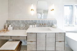 white countertops, gray/blue backsplash, and bright wood cabinetry