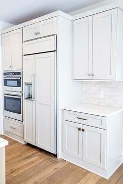 white fridge, white cabinetry and countertops, stainless steel appliances, silver accents