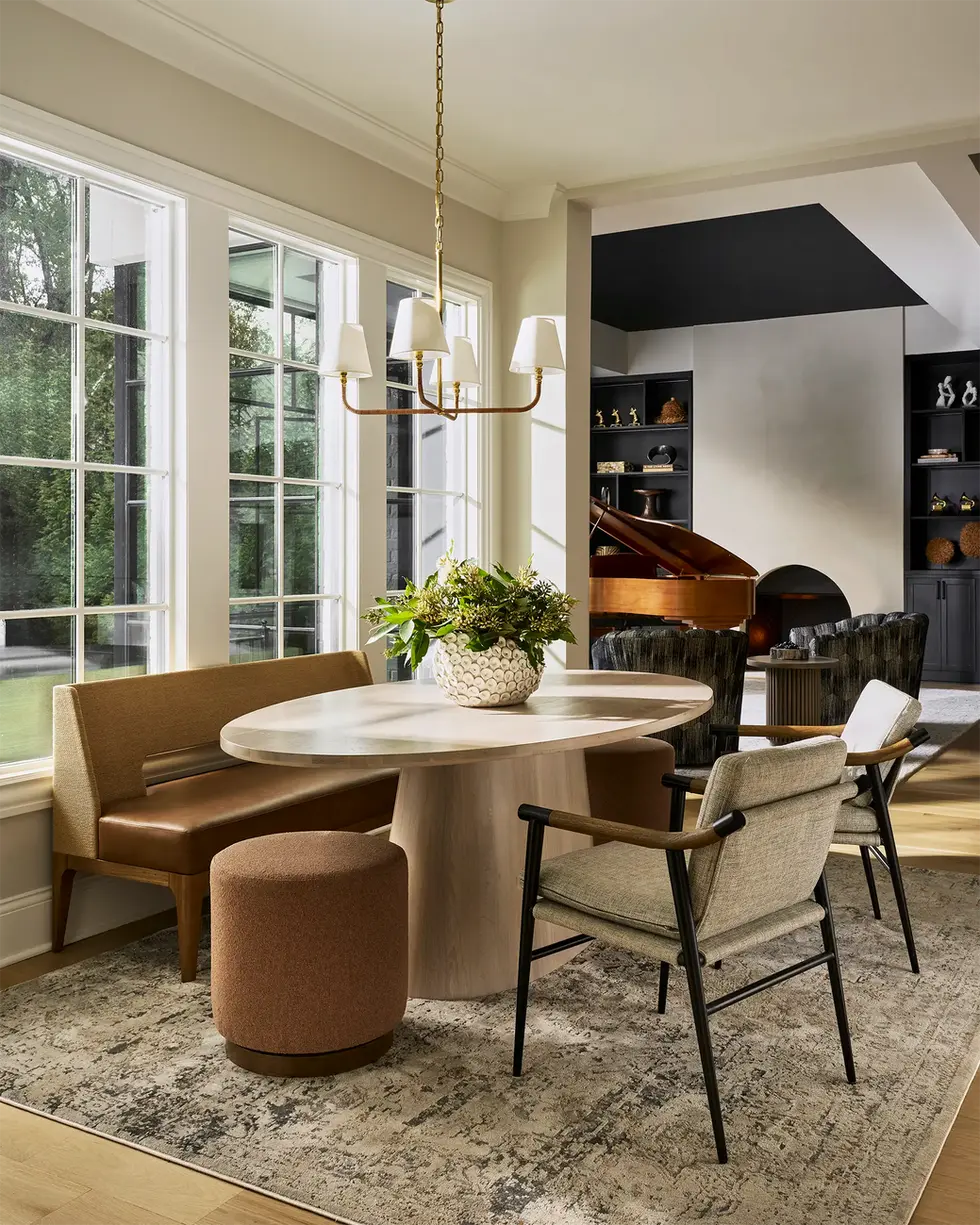 Breakfast area with round table, upholstered seating, and large window