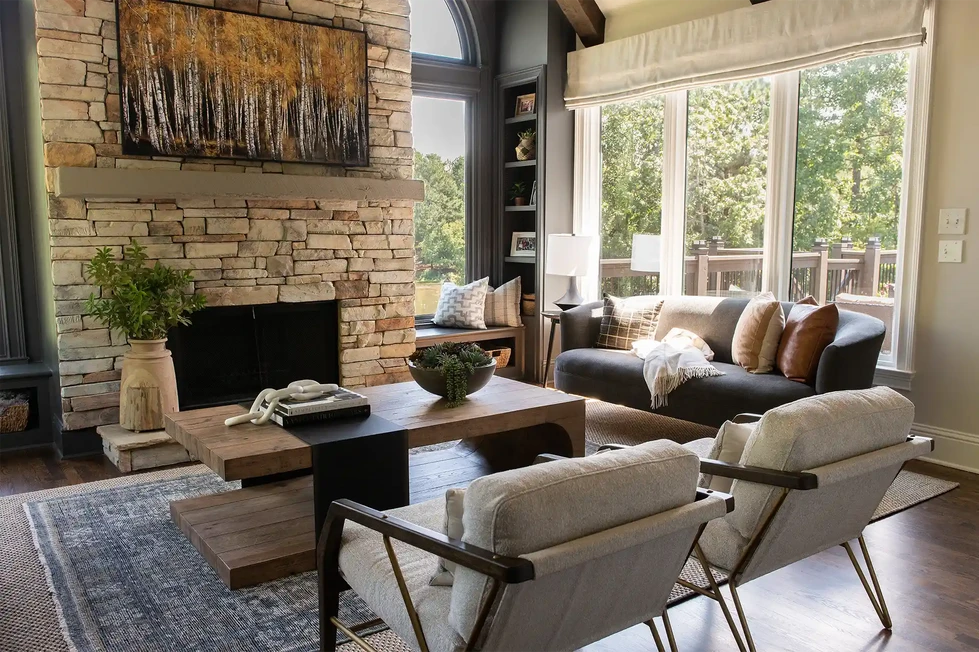keeping room | stacked stone fireplace | modern wood arm chairs | modern wood coffee table | blue sofa | blue couch | blue area rug