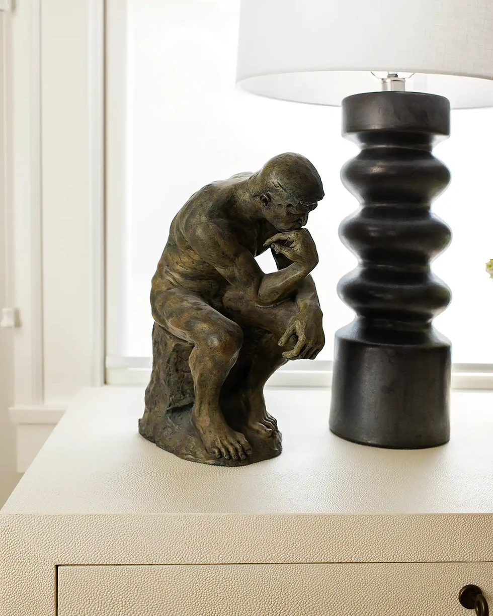 modern white nighstand | black table lamp | bedroom decor | thinker sculpture accessory |