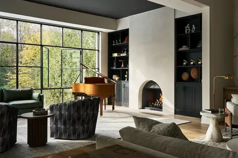 Conservatory with grand piano, lounge seating, fireplace, and floor-to-ceiling black steel windows