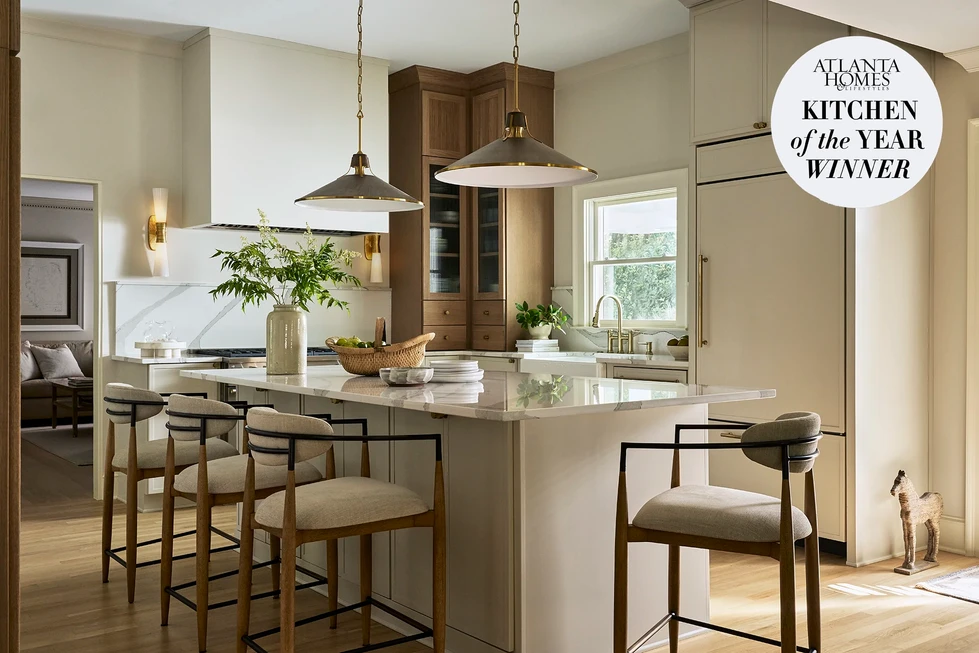 Modern transitional kitchen renovation | two-toned stained and painted cabinetry | modern hood | arched reeded wood cabinets | paneled refrigerator | paneled dishwasher | home bar with ice maker and drawer refrigerators | reeded glass cabinet doors | modern pendant lighting | quartz countertops | upholstered wood barstools