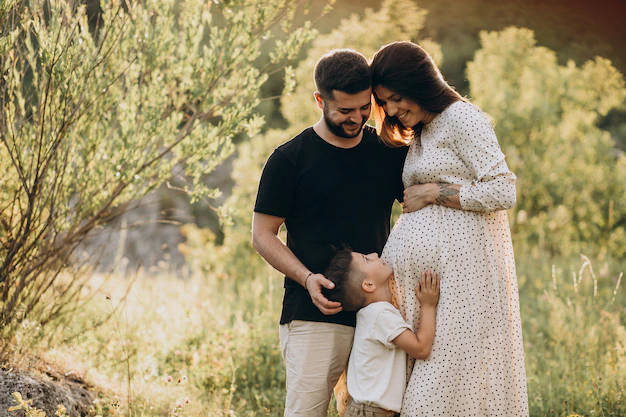 young-pregnant-woman-with-husband-son-forest_1303-24000.webp