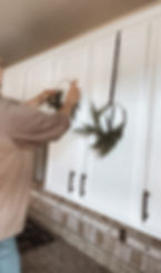 Easy and money saving ways to hang mini wreaths on kitchen cabinet doors.
