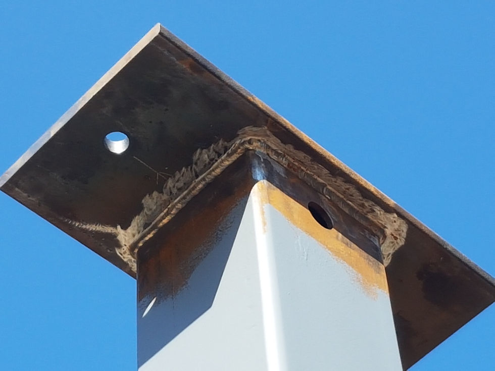 Ironworker guiding suspended steel beam into position during erection