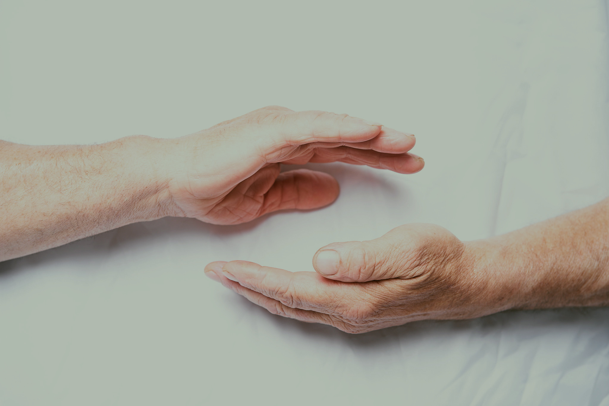 Two hands held gently above and below one another
