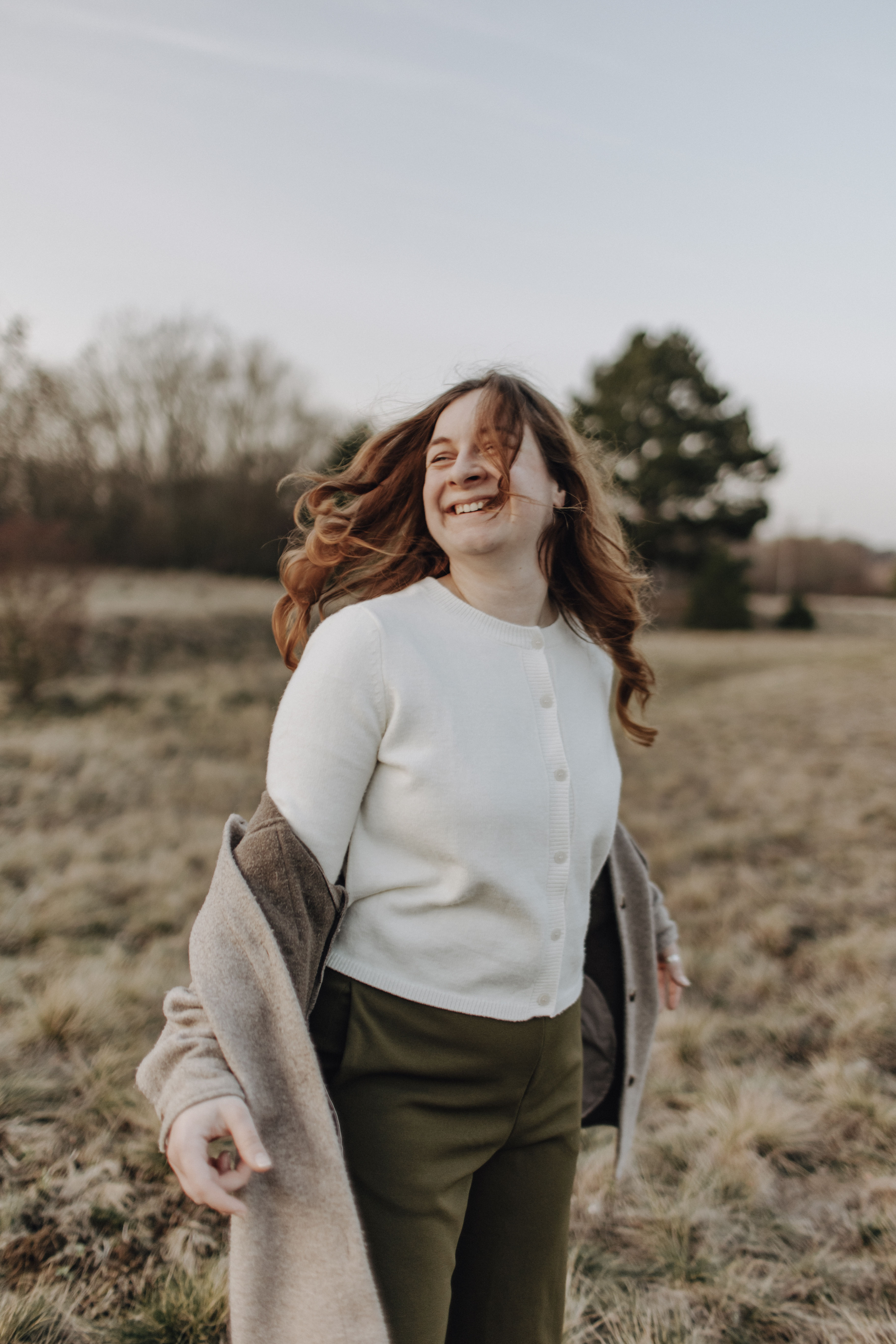Junge Frau mit Brille und Zopf lächelt im Feld, Paket 2, softgoldenpictures.
