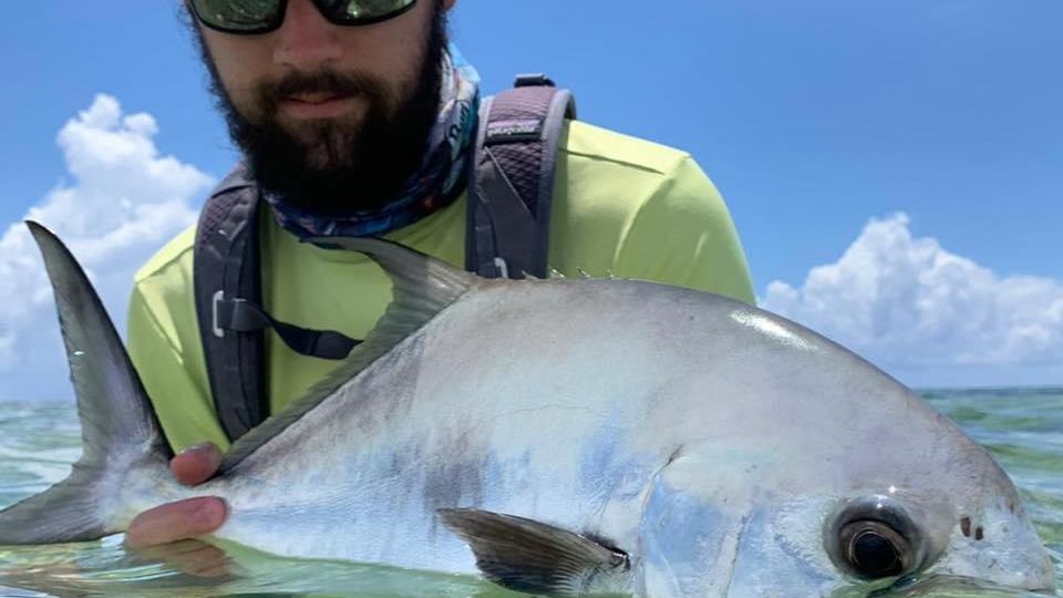 Capt. Will holding a permit in the shallows