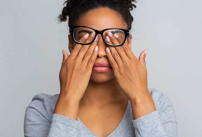 African girl in glasses rubs her eyes, suffering from tired eyes, ocular diseases concept.