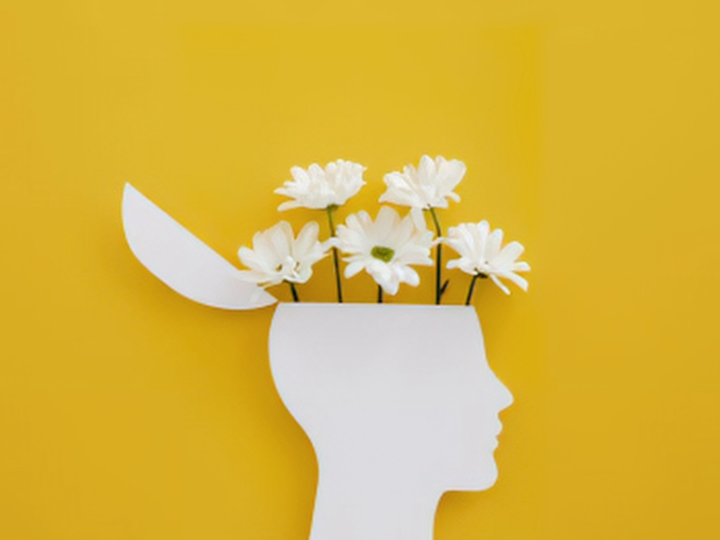 White silhouette head with an open top, white daisies rising out like thoughts, on a bright yellow background.