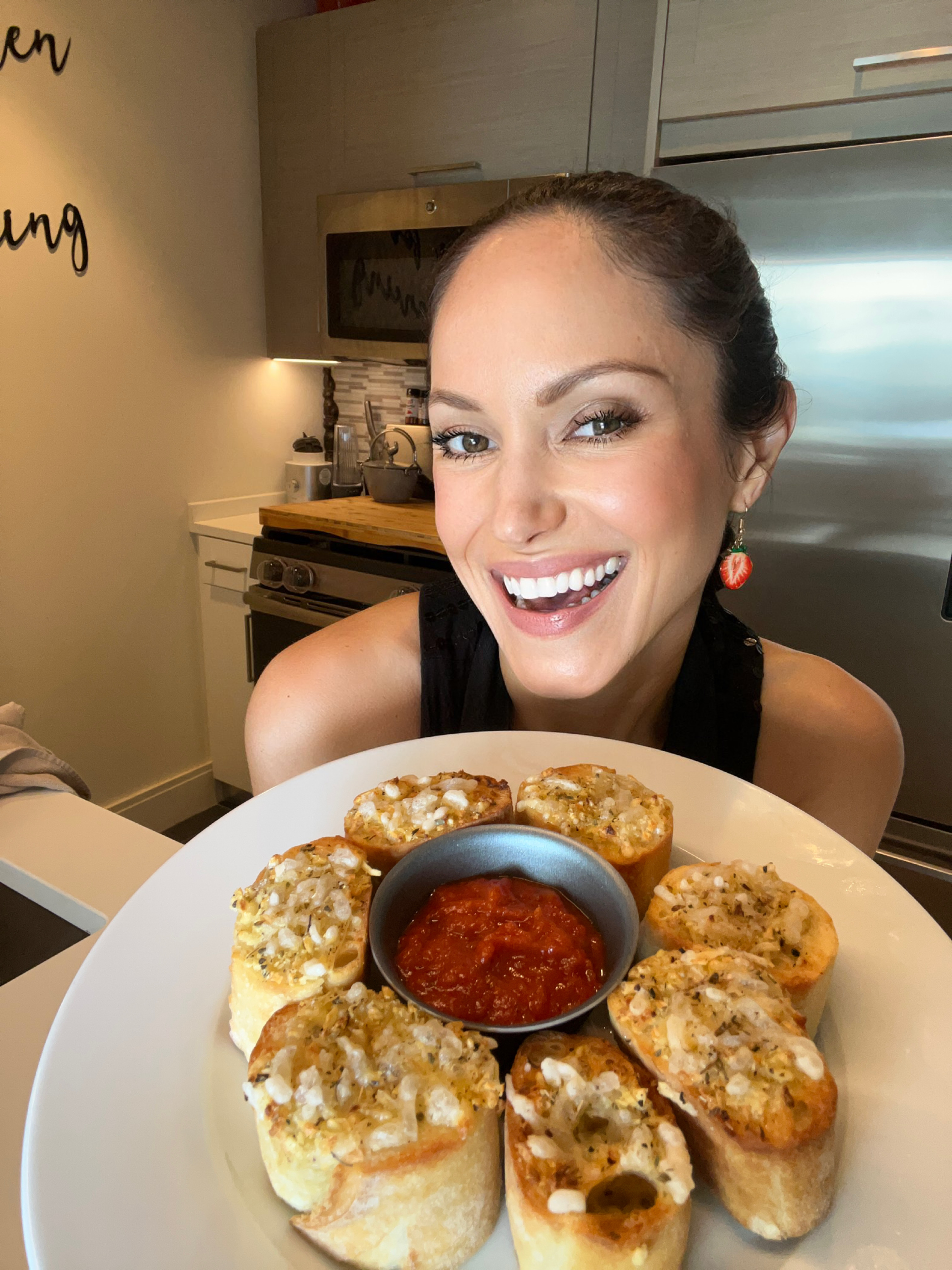 vegan chef holding a plate of cheesy garlic bread