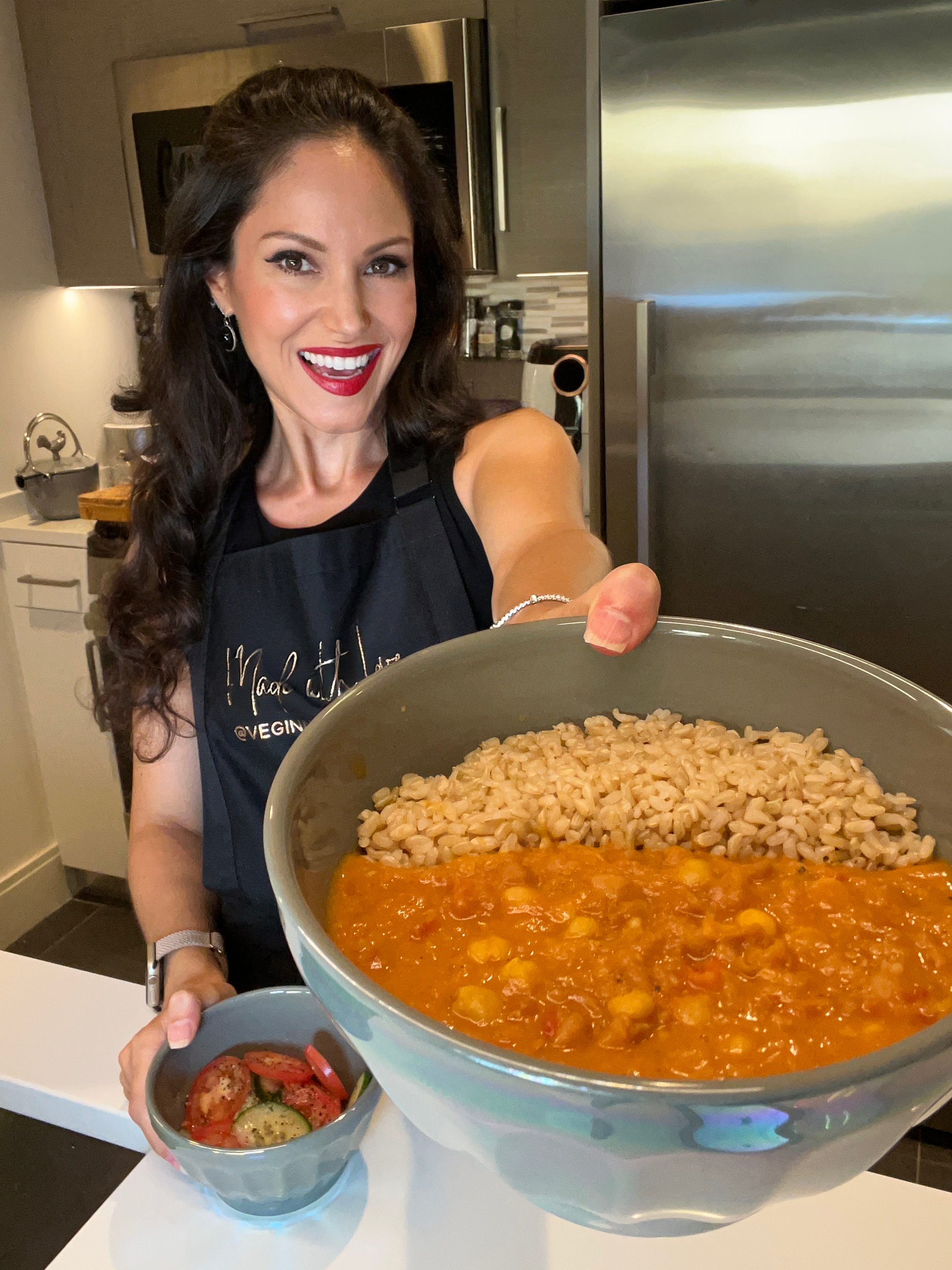 vegan chef holding a bowl of chickpea curry