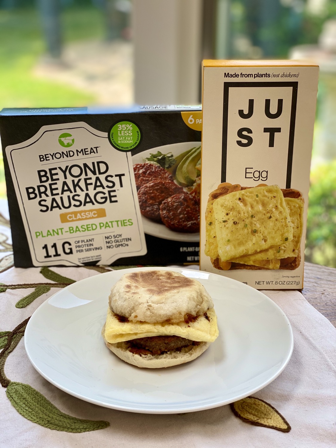 Sausage & Egg Sandwich on plate behind its ingredients