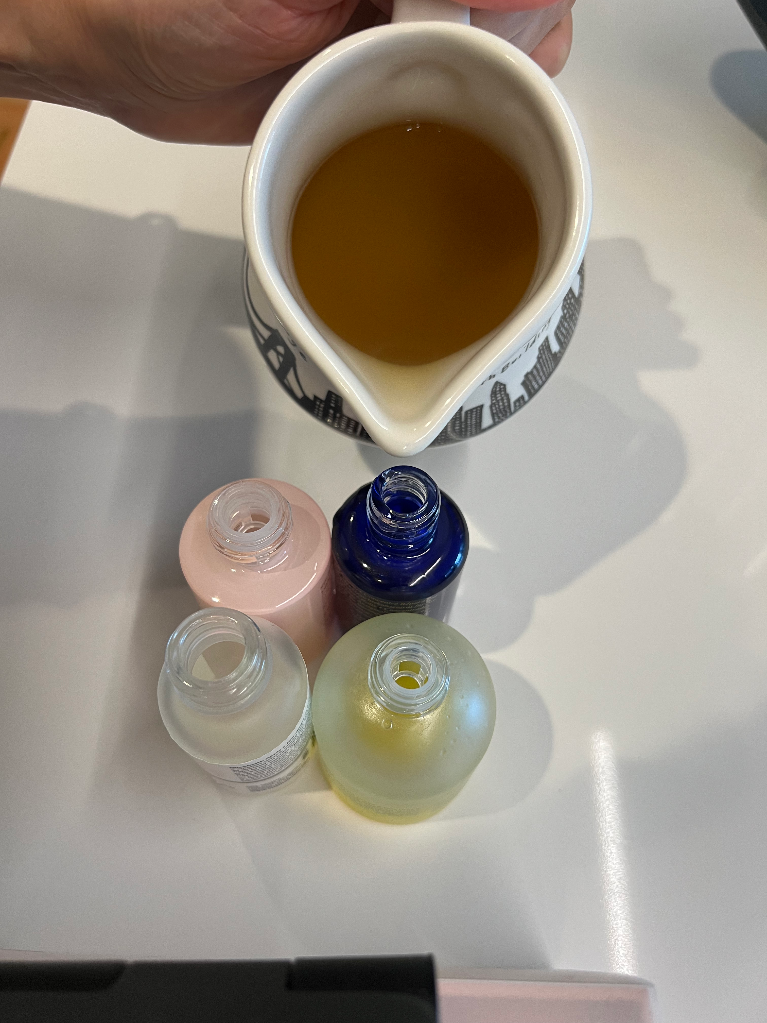 Pouring rosemary water into reusable bottles