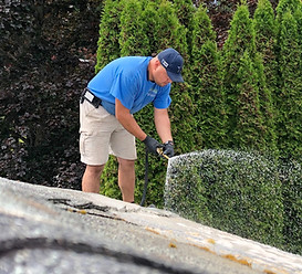 worker spraying hose to clean