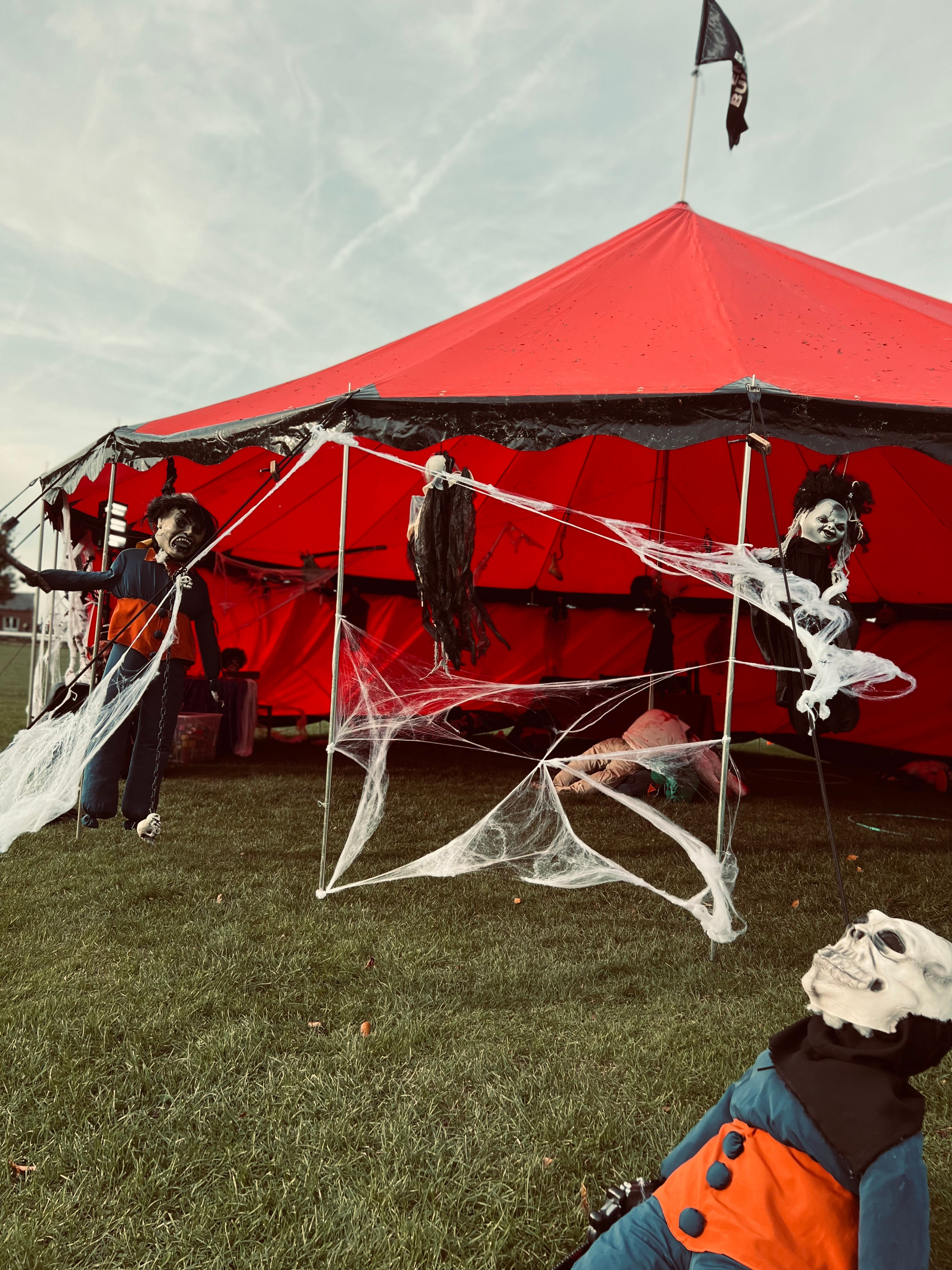 Photo du chapiteau rouge de près décoré avec des éléments horrifiques ainsi que des toiles d'araignées.