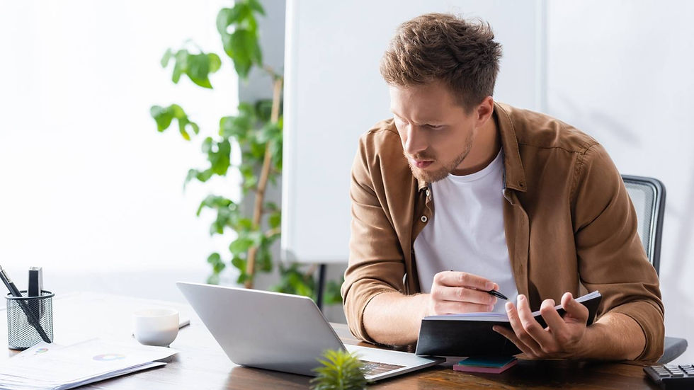 Founder reviewing notes and reports at his desk while deciding whether to rebuild his startup into an AI-native team