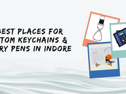 Text "10 Best Places for Custom Keychains & Diary Pens in Indore" with images of a keychain, a calendar, and a set with a pen on a wavy background.