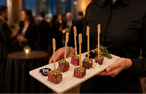 Server presenting steak bites on skewers at a reception