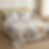 Cama de casal arrumada com jogo de colcha mais duas almofadas cheias, estilo minimalista num quarto iluminado.