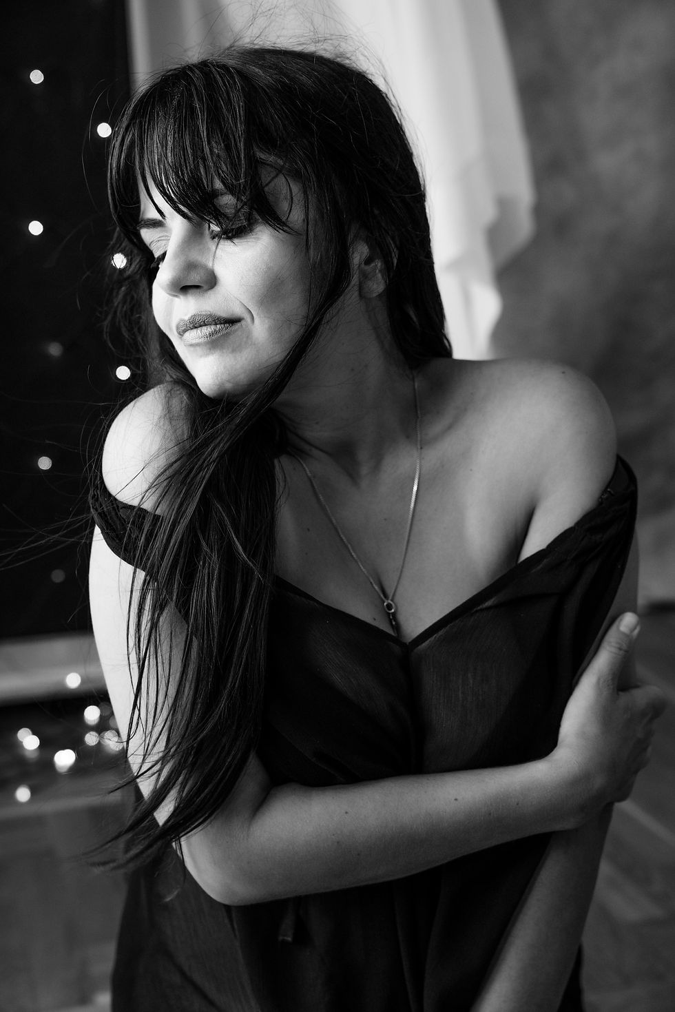 Crno-beli boudoir portret žene u tamnom ogrtaču
