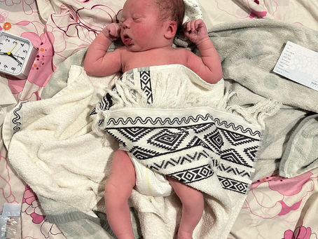 A baby laying on sheets on the floor