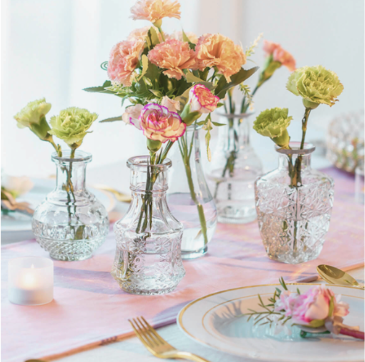 A selection of clear bud vases with floral stems