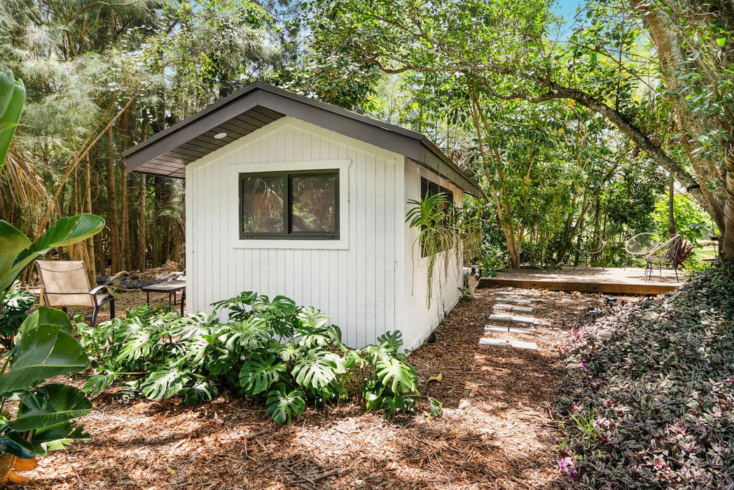 Small white cottage at Farmington Residence surrounded by trees.