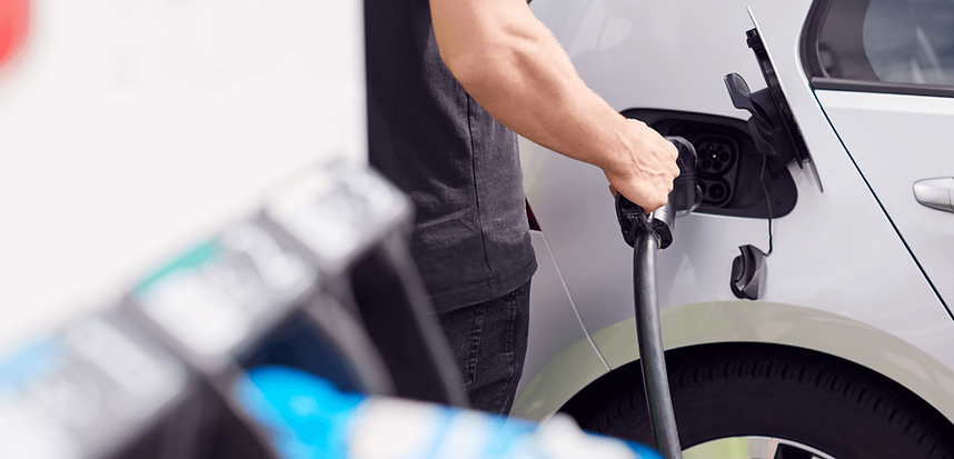 Man plugging in electric vehicle to charge