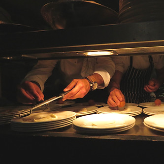 an image from the diners perspective of chefs working in an open kitchen
