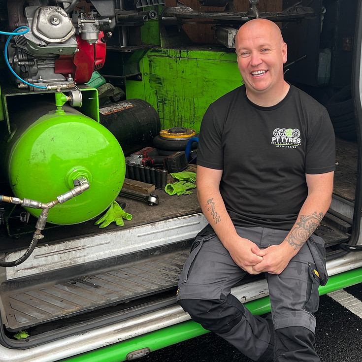 PT Tyres team member smiling in the mobile tyre-fitting van, representing trusted local tyre fitting with a personal touch.