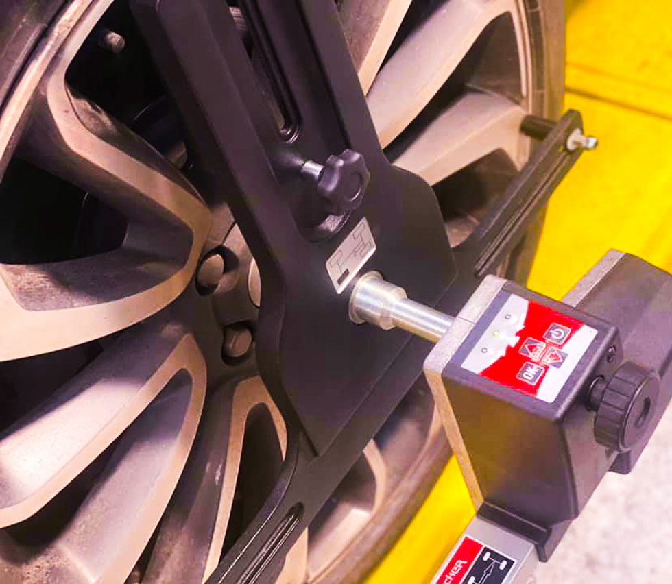 Close-up of a precision wheel alignment tool on a car tyre, representing optional alignment services at PT Tyres’ depot.