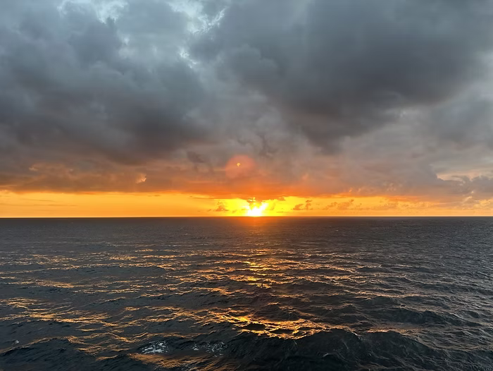 Sea Sunset – A vivid orange sunset casting reflections across the dark blue sea, a dramatic palette of warm and cool contrasts for creative projects.