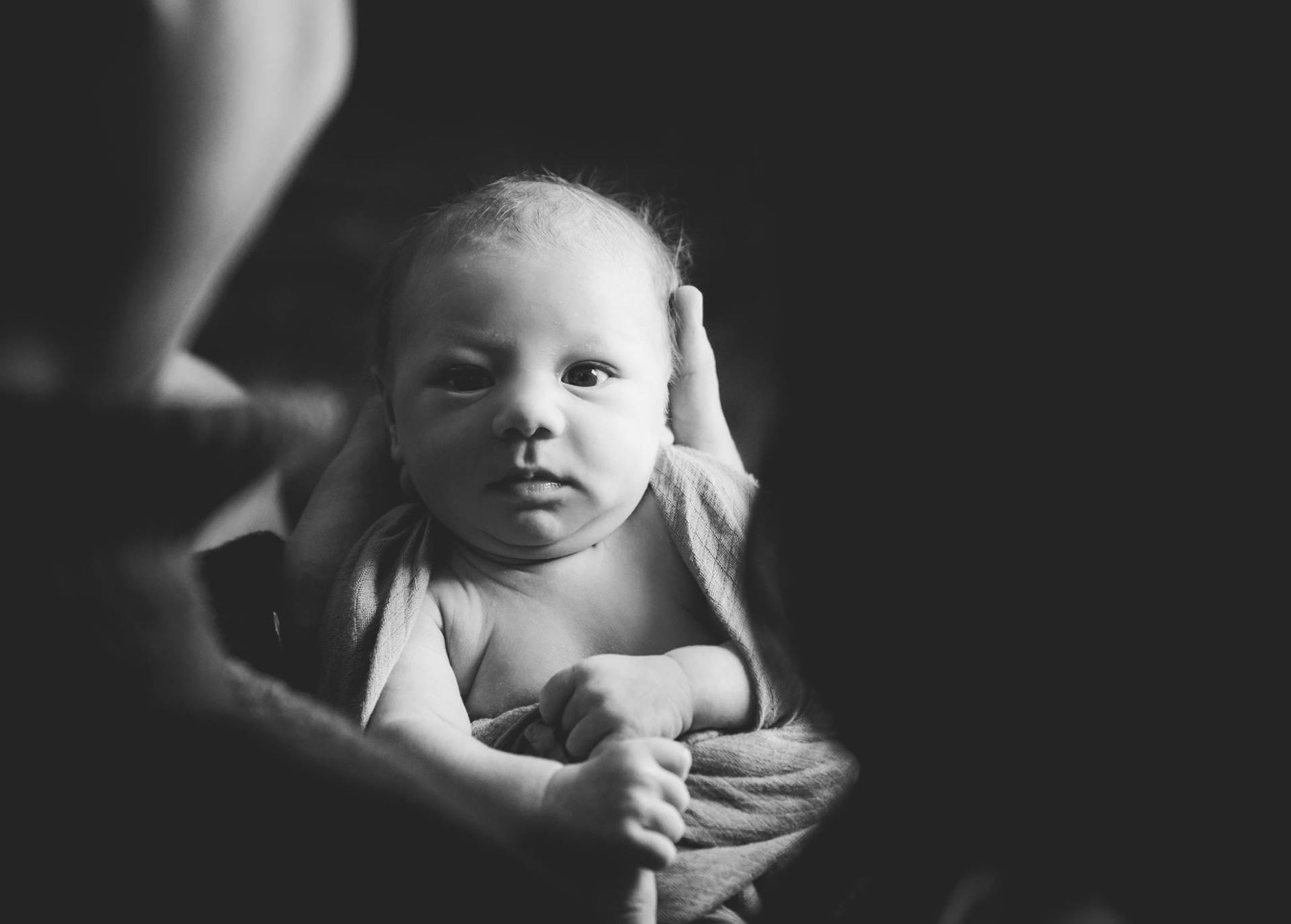 LIfestyle newborn photography with baby awake and both parents enjoying precious moment