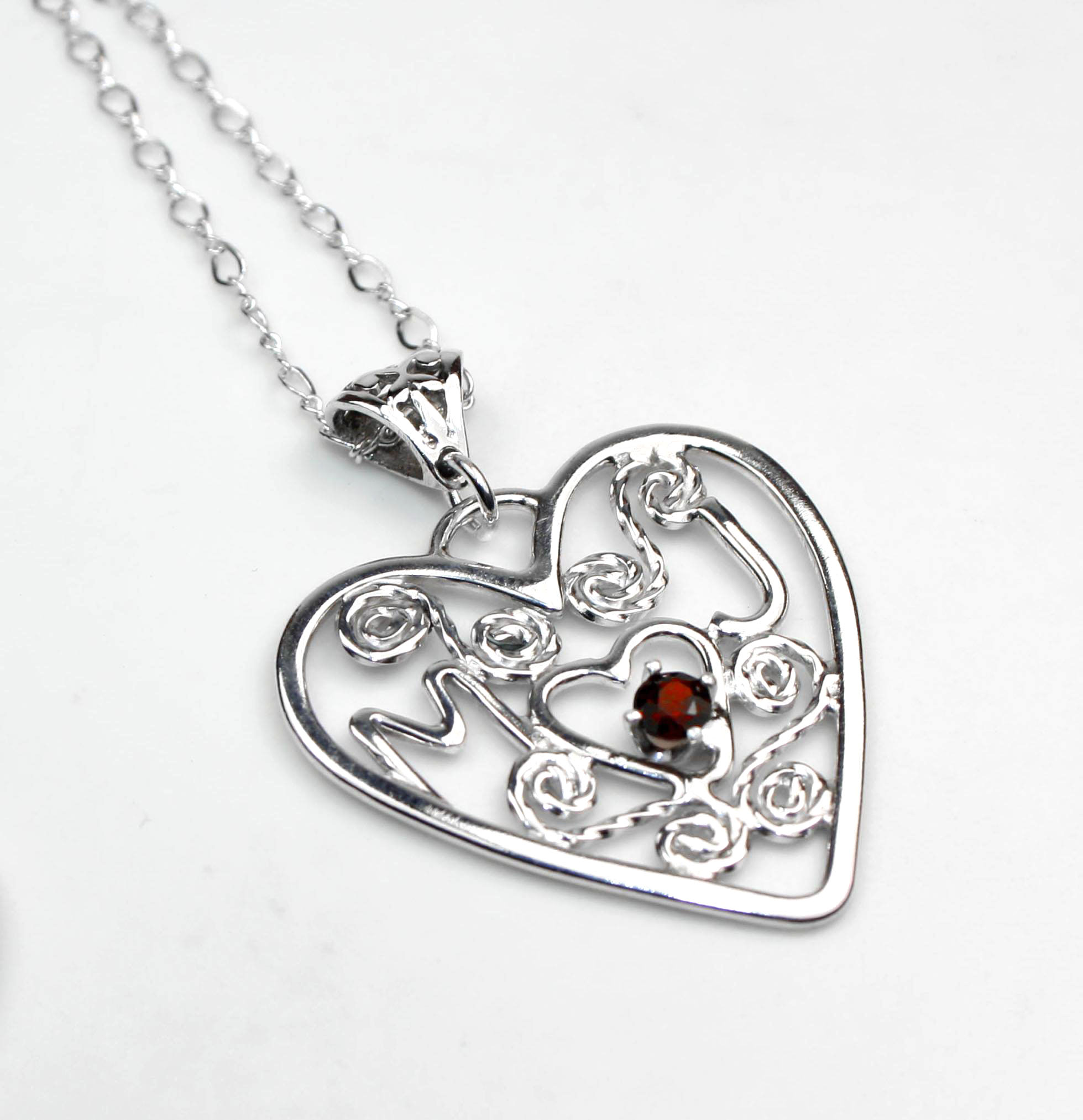 Custom made sterling silver heart pendant featuring initials and garnet