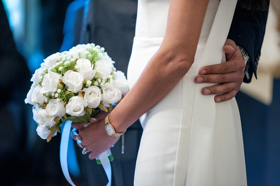 Bride holding a white wedding bouquet with the groom beside her at old marylebone town hall