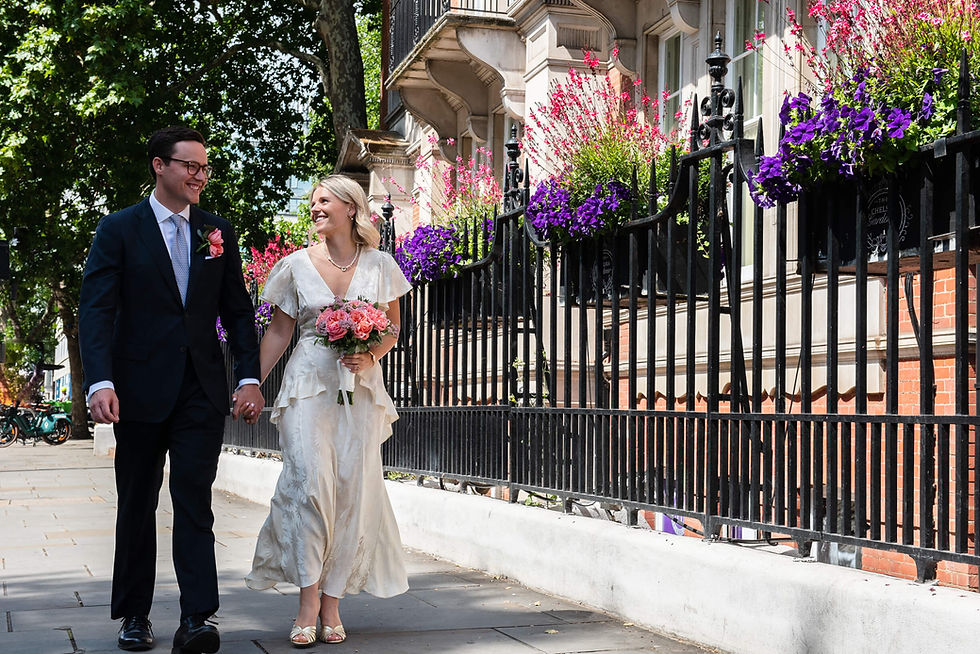 Newlyweds walking together outside chelsea old town hall