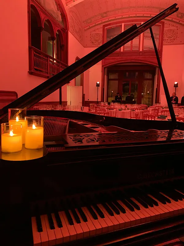 Vue depuis le piano avec bougies et salle élégante en arrière-plan à la Maison de Champagne Taittinger.