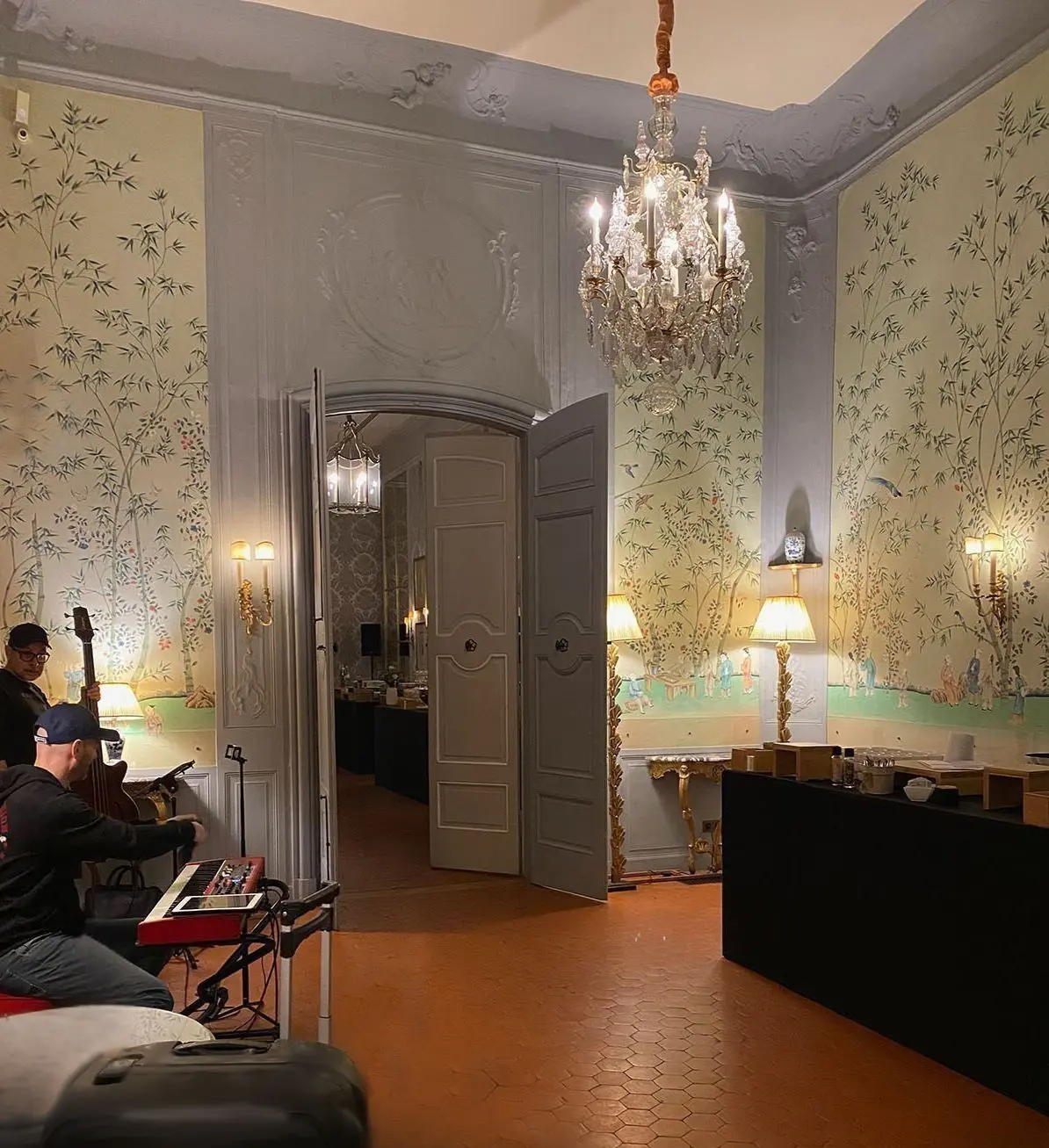 Trio en installation dans un salon de l’Hôtel de Caumont : instruments, chandeliers et fresques murales.